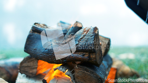 Image of Bonfire circle, camp and outdoor in nature with stone, rock and safe on ground, grass and aerial closeup. Fire, flames and burn wood for heat, cooking or relax on lawn, field and woods for holiday