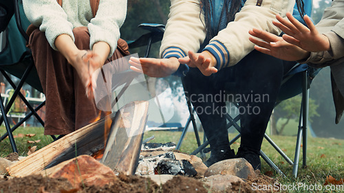 Image of Wood, fire and warm hands on camping, trip or adventure in nature, forest or friends together at a bonfire in winter. Campfire, smoke and group relax on outdoor vacation, holiday or warming hand