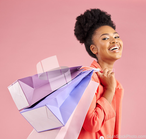 Image of African woman, studio portrait and shopping bag with discount, sale or excited smile by pink background. Young gen z girl, promotion and happy for deal, retail customer experience or fashion for gift