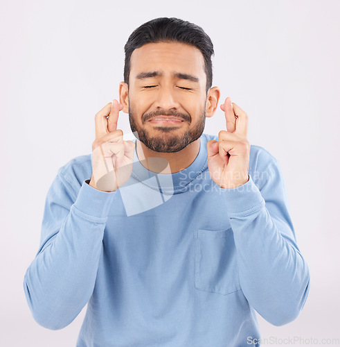 Image of Fingers crossed, hope and asian man in studio with good luck sign for bonus, prize or giveaway on grey background. Eyes closed, wish and Japanese male with emoji for waiting, reward or lotto results