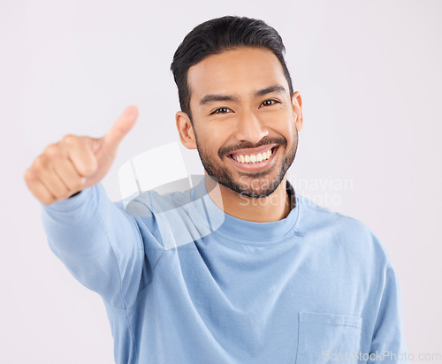 Image of Portrait, smile and asian man in studio with thumbs up, hand or thank you sign on grey background. Happy, face and Japanese male with finger emoji for yes, vote or positive review, success or agree