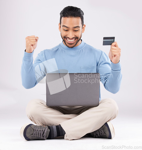 Image of Celebration, laptop and asian man with credit card in studio excited for cashback bonus on grey background. Online shopping, giveaway and male customer with good news, membership or sign up success