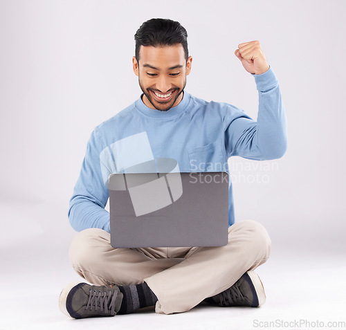 Image of Happy, yes and success with man and laptop in studio for deal, winner and good news. Technology, internet and achievement with person and fist pump on white background for website, wow or celebration