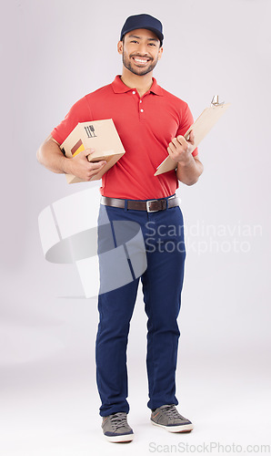 Image of Asian man, portrait and box with clipboard in delivery, signature or checklist against a grey studio background. Male person smile in supply chain, logistics or courier service with parcel or package