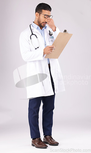 Image of Tired man, doctor and headache with clipboard in burnout, stress or overworked against a grey studio background. Medical or healthcare male person with head pain, mental health or bad clinic results