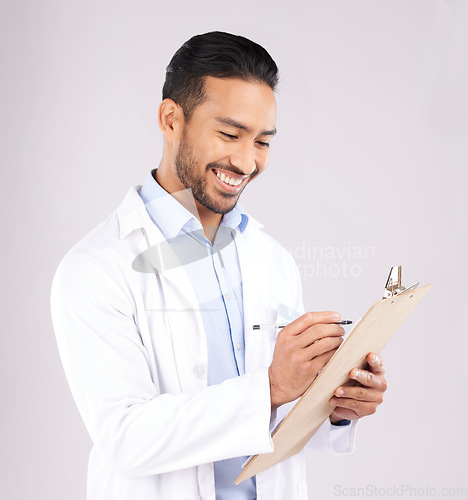 Image of Writing, smile and happy man doctor with checklist in studio for medical, compliance or insurance on grey background. Healthcare, form and male health expert check paperwork or agenda schedule notes