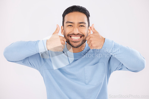 Image of Portrait, thumbs up and man in studio happy with hand, sign and thank you on white background. Smile, face and Mexican person with emoji for yes, vote or positive review, like feedback or agree