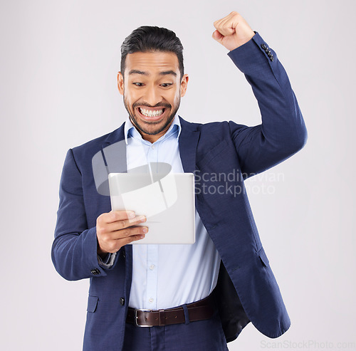 Image of Happy businessman, tablet and fist pump in celebration for winning, promotion or bonus against a grey studio background. Excited asian man on technology for good news, lottery prize or sale discount