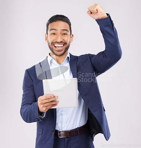 Image of Happy businessman, portrait and tablet with fist pump in celebration for promotion win against a grey studio background. Excited asian man on technology for good news, lottery prize or sale discount