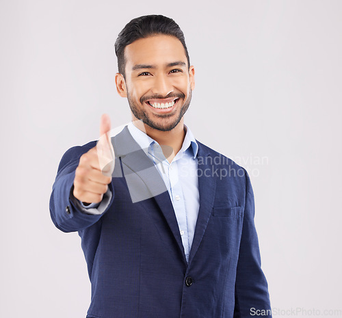 Image of Happy businessman, portrait and thumbs up for success, approval or winning against a grey studio background. Asian man smile with like emoji, yes sign or good job for business agreement and thank you