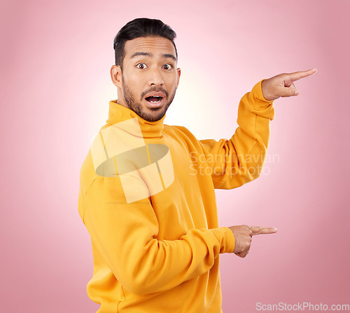 Image of Surprise, pointing and wow with portrait of man in studio for show, announcement and deal. News, advertising and idea with person on pink background for promotion, information and solution mockup