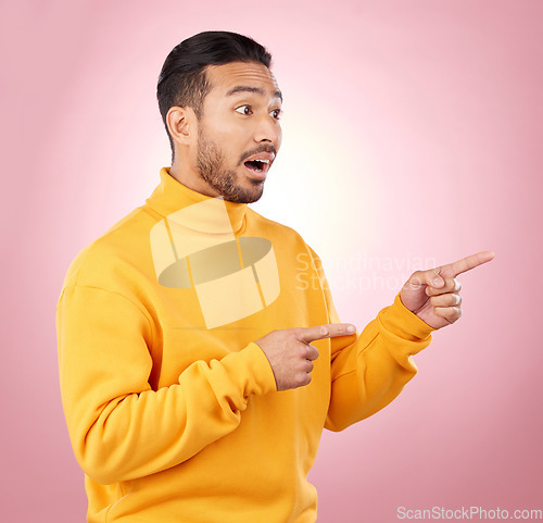 Image of Surprise, pointing and wow with man and space in studio for show, announcement and deal. News, advertising and idea with person on pink background for promotion, information and solution mockup