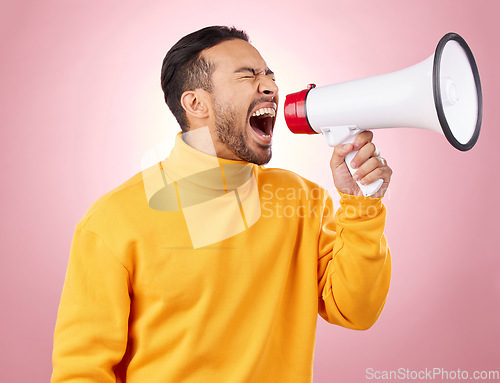 Image of Asian man, megaphone and screaming for discount, sale or alert against a pink studio background. Male person shouting for advertising, marketing or announcement in notification, voice or protest