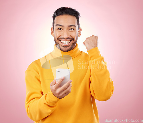 Image of Winner portrait, man and phone for success, yes and celebration of news, social media or gaming results. Excited, mobile games and person with notification or website bonus on studio, pink background