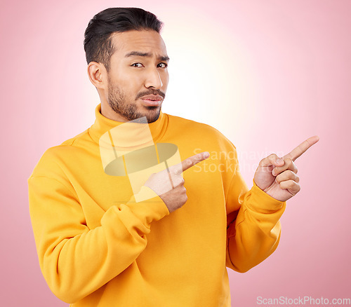 Image of Pointing finger, confused man and portrait in studio with announcement, promotion or decision. Face of serious male asian model with hands for marketing sale, doubt or presentation on pink background