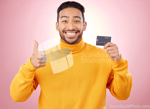 Image of Man, thumbs up and credit card with finance, payment and loan, budget and fashion sale on studio pink background. Portrait, banking success and asian person or gen z for e commerce or shopping emoji