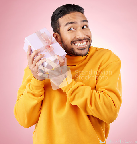 Image of Man, winner and gift box, birthday celebration and prize, excited giveaway or shopping on pink background. Happy person thinking of present, ribbon package and retail sale or competition in studio