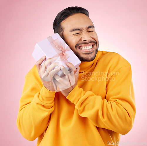 Image of Man, excited winner and gift box, birthday celebration and prize, giveaway or shopping on pink background. Happy person with present, ribbon package and retail sale or competition love in studio