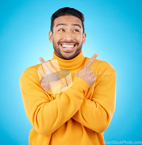 Image of Happy, asian man and hands pointing in studio for choice, deal or sign up decision on blue background. Smile, direction and Japanese guy with recommendation, suggestion or coming soon launch platform