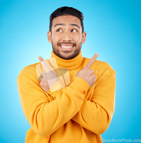 Image of Smile, asian man and hand pointing to studio for news, deal or discount or how to guide on blue background. Happy, choice and male show timeline, checklist or direction, coming soon or sign up info