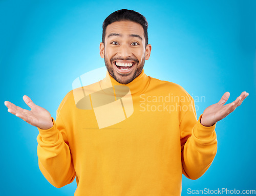 Image of Wow, portrait and happy man in studio with hands for choice, decision or questions on blue background. Palm, scale and face of male customer excited, asking or why emoji for choosing, option or deal