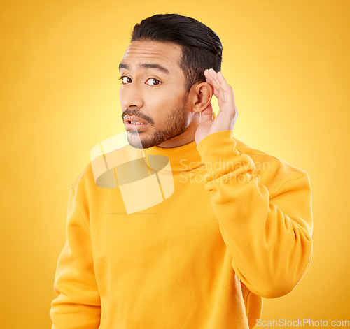 Image of Gossip, whisper and man portrait with hand on ear in studio for speak up body language on yellow background. Secret, listen and face of guy with privacy, news or confidential coming soon promo