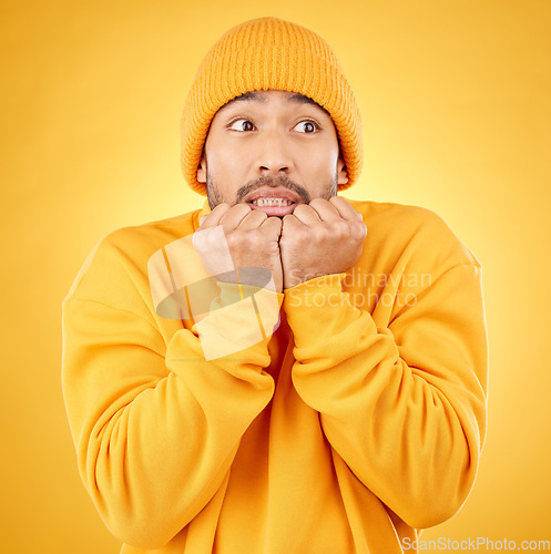 Image of Surprise, face and asian male shocked by winter, fashion and sale announcement in studio on yellow background. Wtf, worry and Japanese male customer with omg deal, news or coming soon promotion