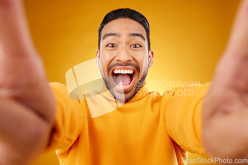 Image of Excited, portrait and selfie of happy man in studio isolated on a yellow background. Face, smile and Asian person taking profile picture for funny memory, laughing and photography on social media