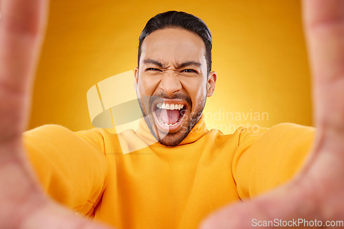 Image of Screaming, portrait and selfie of angry man in studio isolated on a yellow background. Face, shouting and Asian person taking profile picture for memory in anger, frustrated or stress for problem