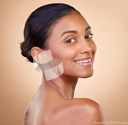 Image of Portrait, beauty or happy woman with natural facial glow with dermatology skincare cosmetics in studio. Face, brown background or aesthetic Indian girl model smiling with , wellness or self love