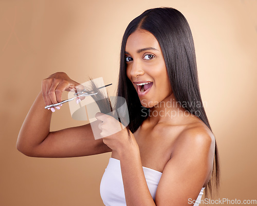 Image of Surprise, cut and portrait of Indian woman with scissors in studio for diy, haircut or styling on brown background. Wow, face and female model with hair, treatment or styling results with beauty tool