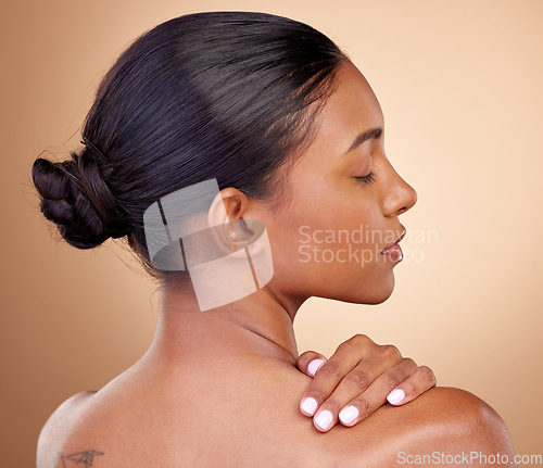 Image of Beauty, face and woman touch back with natural skincare shine, cosmetics treatment and morning self care routine. Spa salon, dermatology or Indian person with anti aging skin glow on brown background