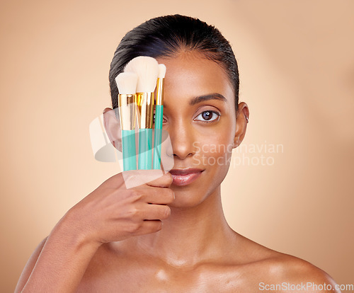 Image of Beauty, makeup and brush with portrait of woman in studio for facial, foundation and self care. Cosmetics, product and tools with face of model on brown background for glow, skincare and dermatology