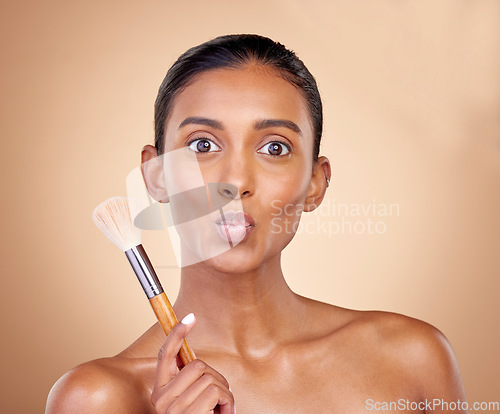 Image of Kiss, makeup and brush with portrait of woman in studio for beauty, foundation and self care. Cosmetics, product and tools with face of model on brown background for glow, skincare and dermatology