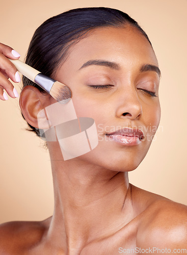 Image of Beauty, makeup and foundation with woman and brush in studio for facial, relax and self care. Cosmetics, product and tools with face of model on brown background for glow, skincare and dermatology