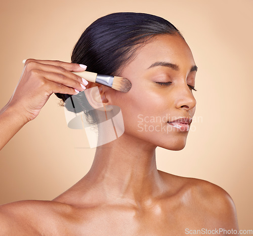 Image of Beauty, makeup and cosmetics with woman and brush in studio for facial, foundation and self care. Relax, product and tools with face of model on brown background for glow, skincare and dermatology