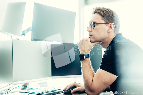 Image of Stock broker trading online watching charts and data analyses on multiple computer screens.