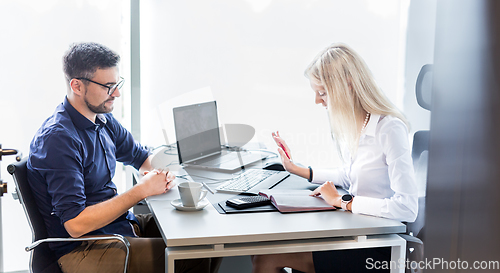 Image of Business meeting. Client consulting. Confident business woman, real estate agent, financial advisor explaining details of project or financial product to client in office.