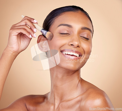 Image of Beauty, makeup and smile with woman and brush in studio for facial, foundation and self care. Cosmetics, product and tools with face of model on brown background for glow, skincare and dermatology