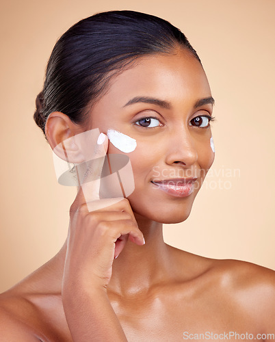 Image of Face, beauty and woman, cream and cosmetics with skincare product on studio background. Indian female model in portrait, healthy glow and lotion on skin, dermatology and moisturizer with facial