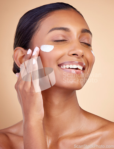 Image of Woman, happy skincare and cream for facial beauty, apply lotion and dermatology or cosmetics. Skin care product, face and young person or model sunscreen or moisturizer on a brown studio background