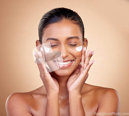 Image of Facial cream, skincare smile of woman for aesthetic shine, cosmetics or clean dermatology on studio background. Happy indian female model, face lotion or sunscreen product for healthy beauty glow
