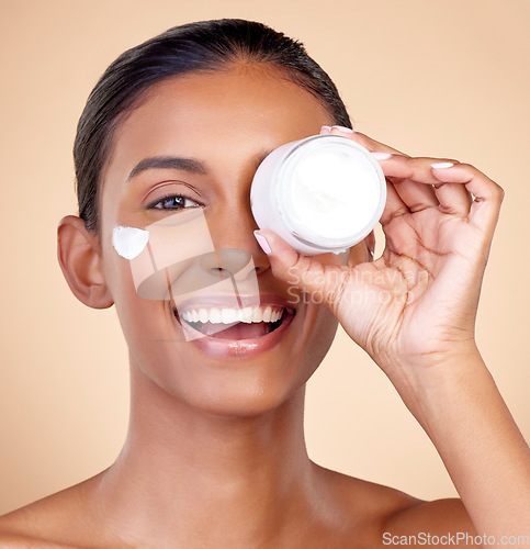 Image of Woman, portrait and cream container of eye skincare, dermatology and cosmetics or self care. Facial product, happy face and young person or beauty model in skin care lotion on studio brown background