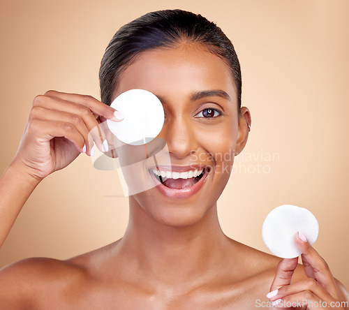 Image of Happy woman, cotton pad and skincare for eyes, face or aesthetic cosmetics on studio background. Portrait of indian female model, beauty and facial product for makeup, toner wipe or clean dermatology