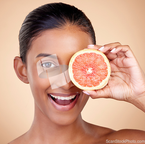 Image of Happy woman, portrait and grapefruit, natural beauty and vitamin c with sustainable skincare on studio background. Face, female model and citrus fruit, eco friendly dermatology and cosmetic care