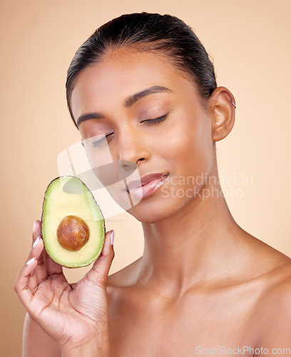 Image of Avocado, facial beauty and woman in studio, background and omega 3 for aesthetic wellness. Face of calm indian female model, natural skincare and fruit for sustainable cosmetics, healthy food or glow