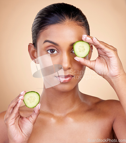 Image of Cucumber, skincare and portrait of woman in studio, background or aesthetic shine. Face of indian female model, natural beauty and cooling fruits for sustainable cosmetics, healthy dermatology or spa