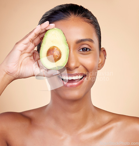 Image of Avocado, skincare and portrait of happy woman in studio, background or aesthetic glow. Face of indian female model, natural beauty and fruit for sustainable cosmetics, healthy food or facial benefits