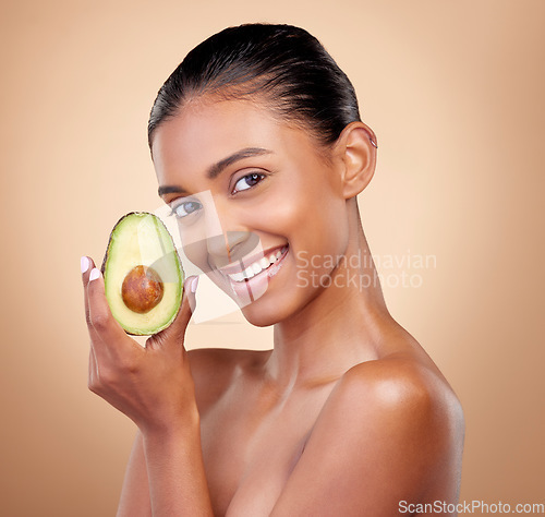 Image of Avocado, beauty and portrait of happy woman in studio, background and aesthetic glow. Face of indian model, natural skincare and fruit for sustainable cosmetics, vegan dermatology and facial benefits