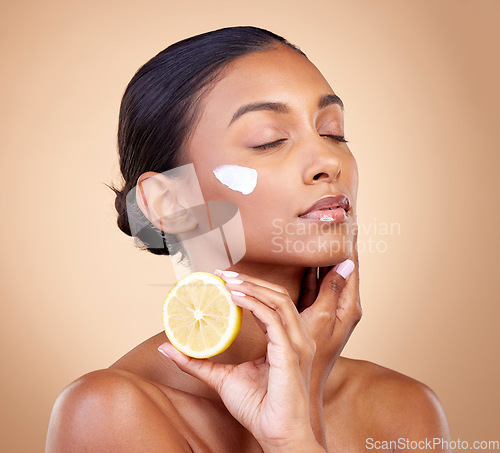 Image of Woman, lemon and cream for beauty, natural skincare product and cosmetics or vitamin c benefits and thinking. Person sleeping with face lotion, fruits and skin dermatology on brown, studio background